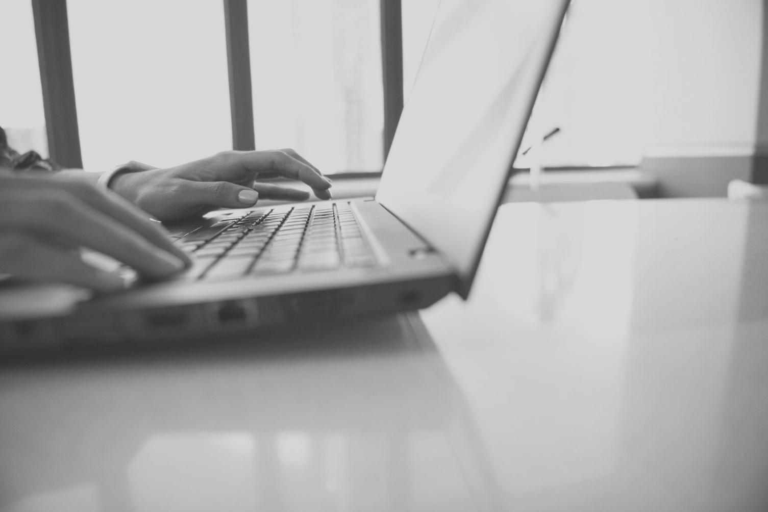 Personne analysant des graphiques financiers sur un ordinateur portable